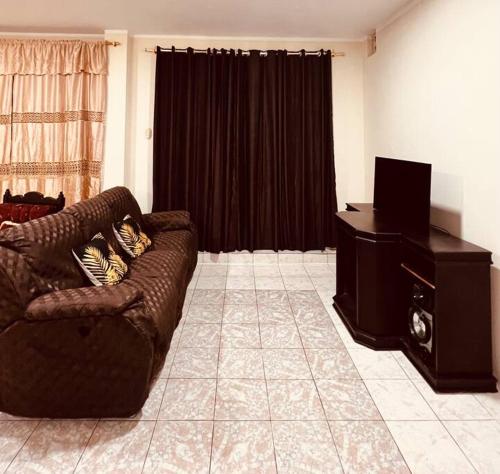 a living room with a couch and a piano at Amplia, independiente y segura vivienda de 2 habitaciones in Machala