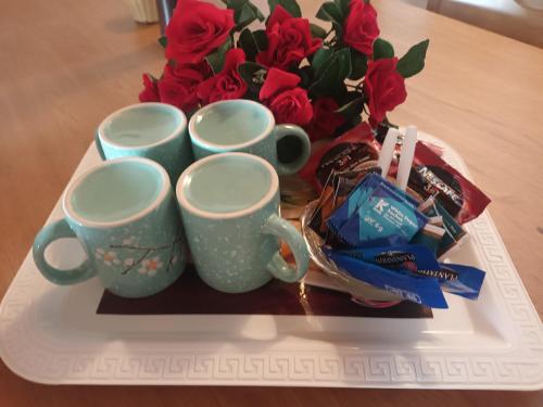 a tray with three cups and a bouquet of red roses at Lovely FLowers in Mount Lavinia in Mount Lavinia