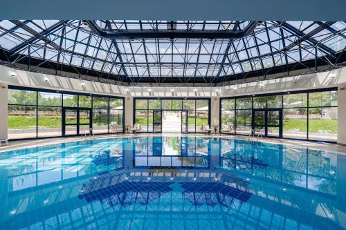 una gran piscina con techo de cristal en International Hotel Tashkent, en Tashkent