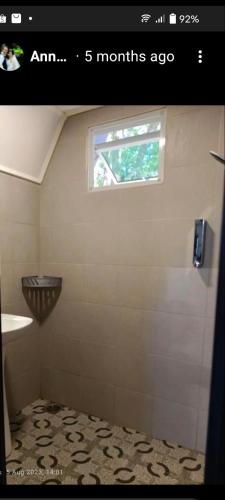a bathroom with a shower with a window and a sink at The Mangrove in Sematan