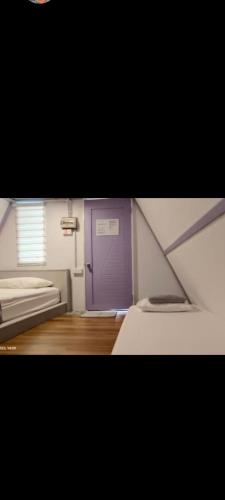 una piccola camera con una porta viola e una finestra di The Mangrove a Sematan