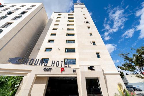 un alto edificio bianco con un cartello dell'hotel di Hound Hotel Mokpo Peace Plaza a Mokpo