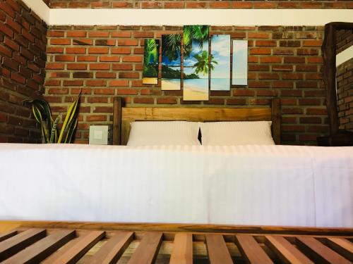 una camera con un letto bianco e un muro di mattoni di Euro star holiday inn a Wennappuwa