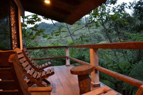 uma varanda de uma casa com cadeiras e uma mesa em CABAÑA EL SALTO 2 em Tzicuilán