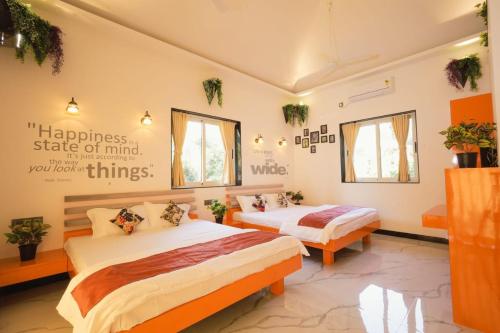 a bedroom with two beds and a sign on the wall at Cherryleen Resort Nagaon Alibaug in Nagaon