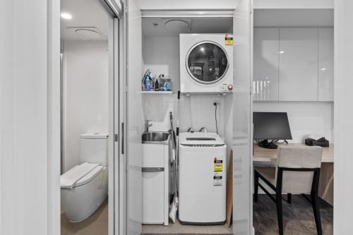 La petite salle de bains est pourvue de toilettes et d'un lavabo. dans l'établissement Hearty Milton Apartments, à Brisbane