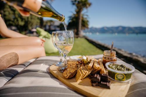 a woman is pouring champagne into a wine glass at Akaroa Waterfront Motels in Akaroa