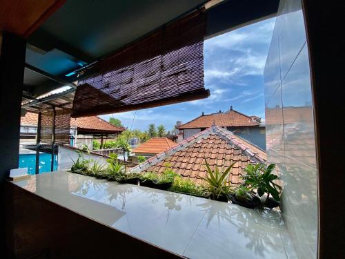 Habitación con vistas a una casa desde una ventana en Sawitri Homestay en Padangbai