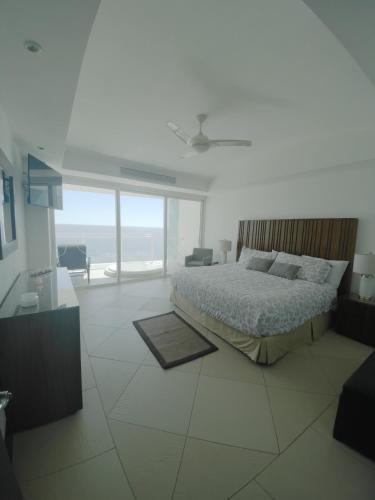 a bedroom with a bed and a view of the ocean at Bay View Grand Marina Ixtapa condo en pie de playa in Ixtapa