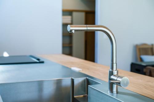 a kitchen sink with a faucet on a counter at 【海から近く】敷地内無料駐車場5台分完備！BBQ設備貸出あり3,500円！快適空間！【COQAEL】 in Oda
