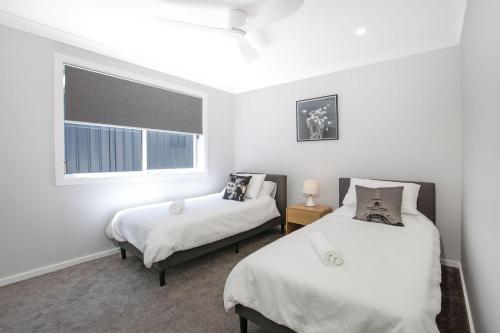 a bedroom with two beds and a window at La Vista - Water Views & Mountain Vistas in Culburra Beach