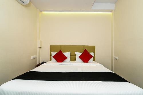 a bedroom with a large bed with red pillows at Super Capital O Hotel Siddartha Grand in Mohammadnagar