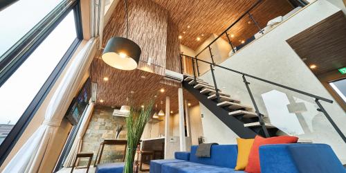 a living room with a blue couch and a staircase at Rakuten STAY VILLA Yamanakako in Yamanakako