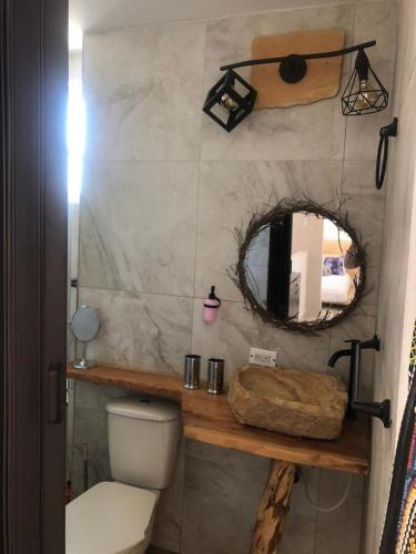 a bathroom with a toilet and a mirror at Casa vacacional en ricaute Cundinamarca in Ricaurte