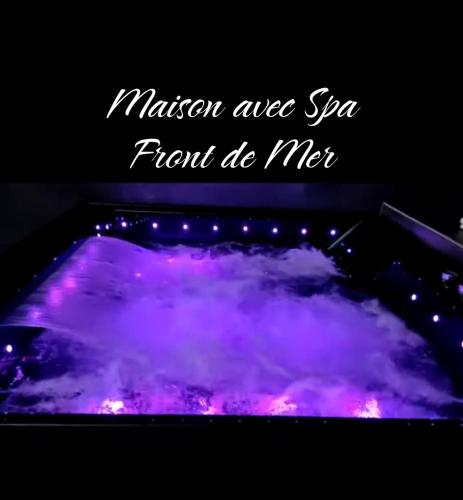 une baignoire remplie d'eau violette et rose dans l'établissement Maison avec spa en front de mer, au Barcarès