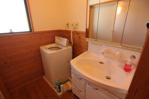 uma casa de banho com um lavatório e uma máquina de lavar roupa em 都留市エコハウスで移住体験を em Tsuru 