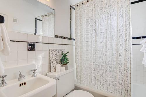 Baño blanco con aseo y cortina de ducha en Highly desired Lindley Park home in Greensboro en Greensboro