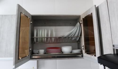 a cupboard with plates and dishes in it at VILLAVICENCIO! Increíble, Hermoso y moderno APARTAMENTO COMPLETO, con PISCINA! in Villavicencio
