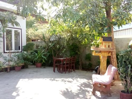un patio con sillas, una mesa y una casa de aves en The Chill River-Boutique Villa, en Siem Reap
