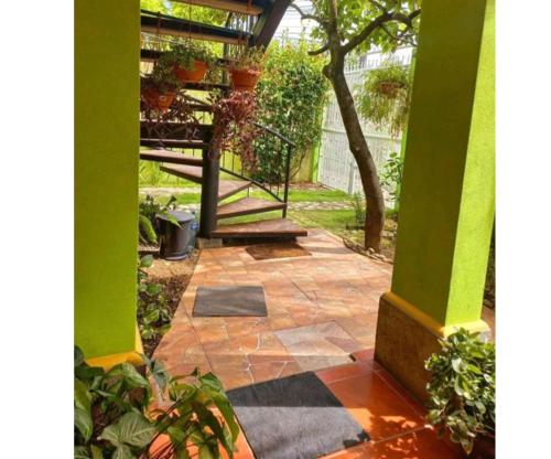 un patio esterno con colonne verdi e una scala di Hostal San Antonio a León