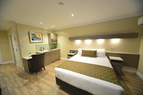um quarto de hotel com uma cama e uma secretária em Bentley Motel em Perth