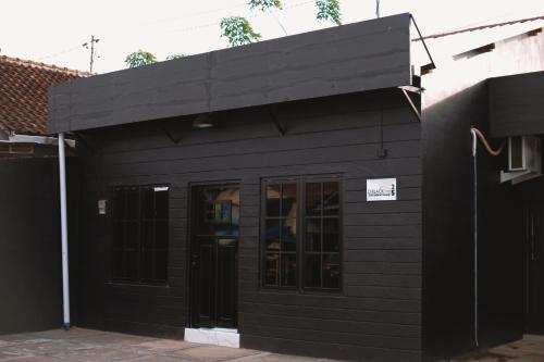 un edificio negro con un cartel. en D Black Houze Banyuwangi en Banyuwangi