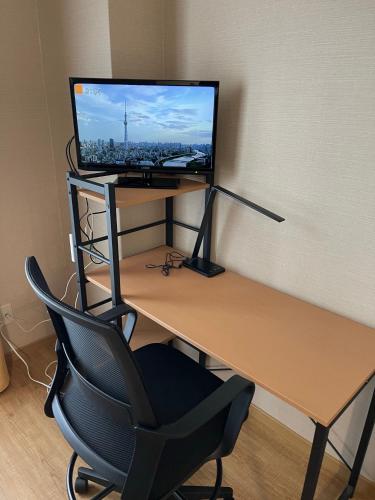 a desk with a computer monitor and a chair at The Global West in Niihama