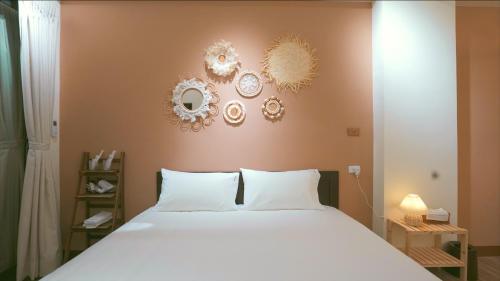 a bedroom with a white bed and some mirrors on the wall at 咻咻宿 Xiuxiu 電梯宅 in Taitung City