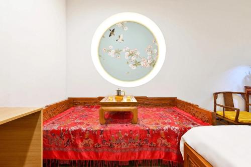 um quarto com uma mesa num tapete vermelho em Xingshe Alley Courtyard Hotel Beijing Wangfujing Forbidden City Branch em Pequim