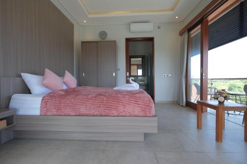 a bedroom with a large bed with a swan on it at Mesari Villa in Keramas
