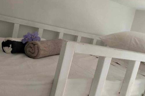 Dream Cove Cottage, 2 Bedroom في بورت فيلا: سرير عليه منشفة وزهرة