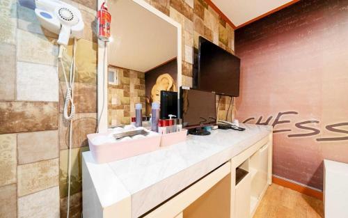 La salle de bains est pourvue d'un lavabo et d'une douche avec un miroir. dans l'établissement Chess Motel, à Séoul