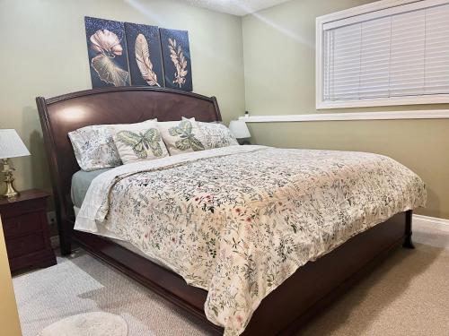 a bedroom with a bed with a floral bedspread at Renovated Registered Walkout Suite with King bed, Kitchen and Parking in Calgary