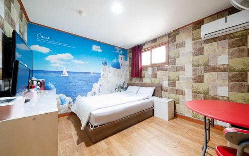 a bedroom with a bed and a wall with a mural at Chess Motel in Seoul