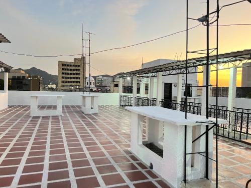 a rooftop patio with white tables on a building at Hotel Costa Norte in Santa Marta