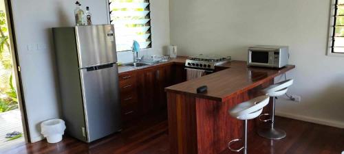 a kitchen with a stainless steel refrigerator and a counter at Dream Cove Cottage, 2 Bedroom in Port Vila