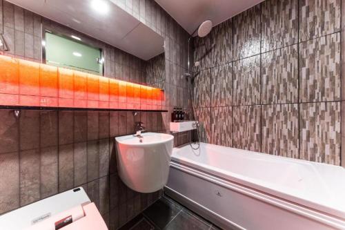 a bathroom with a tub and a toilet and a sink at Y Hotel in Seoul