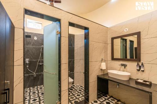 a bathroom with a sink and a mirror at StayVista's Majestic Mud House - Rajasthani Architecture with Modern Amenities, Outdoor Pool, Adventure Activities, and Spa in Pushkar