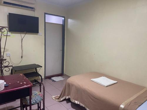um quarto com uma cama e uma televisão de ecrã plano em OYO 90914 Hotel Mei Wah em Kampong Selanchor