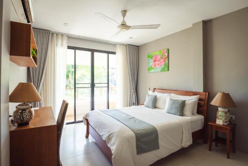 a bedroom with a bed and a large window at Samahita Retreat in Laem Sor