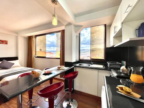 a kitchen with red stools in front of a counter at Allincay Cusco Apart Hotel in Cusco