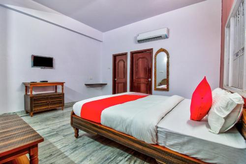 - une chambre avec un lit, un bureau et une télévision dans l'établissement OYO Atithi Bhawan, à Jamshedpur