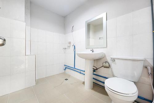 a white bathroom with a toilet and a sink at Freesia Bangphi Guest House in Samutprakarn