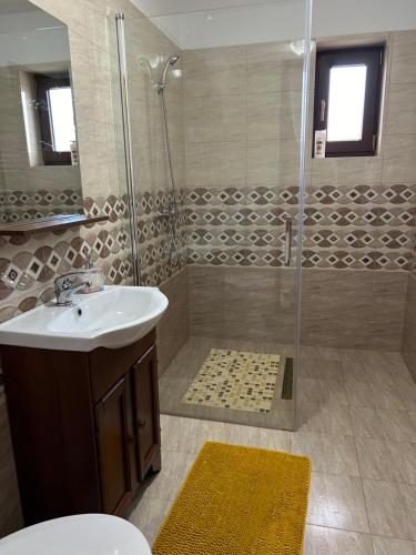 W łazience znajduje się umywalka i prysznic. w obiekcie Gura Raului Casa de Vacanta w mieście Gura Râului