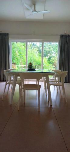 a table in a room with a large window at Wayanad Empire Colonial Villa in Kalpetta