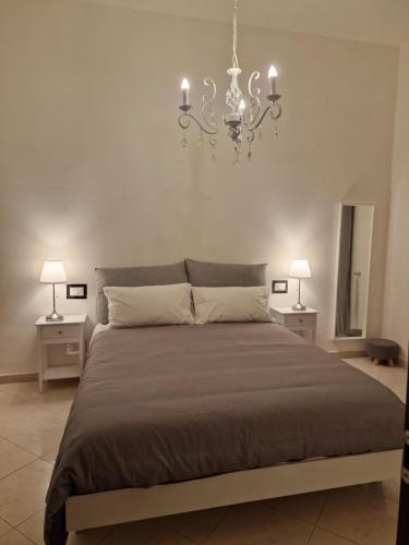 ein Schlafzimmer mit einem großen Bett mit einem Kronleuchter in der Unterkunft Cinzia's House of Mirrors in Pisa