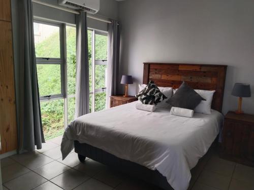 a bedroom with a bed and a large window at 5 Telena in Umdloti