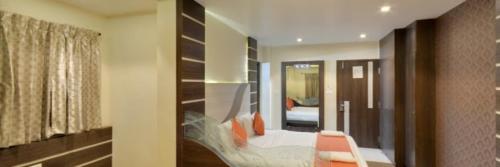 um quarto com um corredor com uma cama e um espelho em Hotel SBS Grand , Coimbatore em Coimbatore