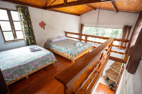 Kleines Zimmer mit 2 Betten und einer Bank in der Unterkunft Rec. Harmonia Wi-Fi Piscina Churrasqueira Lareira in Juquitiba