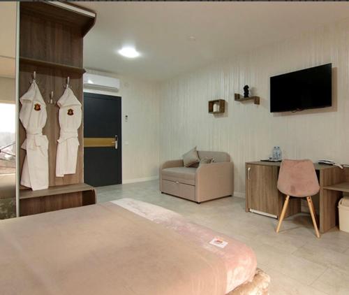 ein Schlafzimmer mit einem Bett, einem Sofa und einem TV in der Unterkunft Four Seasons In Carpathians in Myhowe